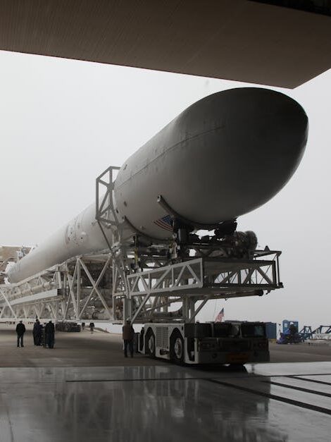 New installed rocket booster placed on transporter platform and moving into vehicle assembly building in space center on cloudy day