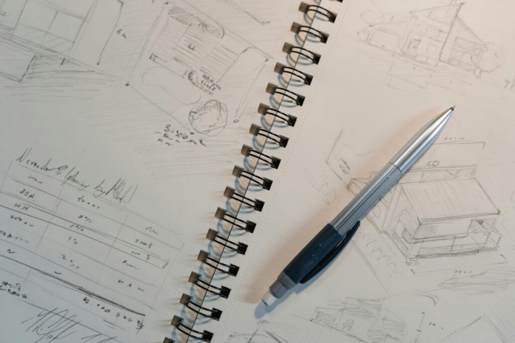 Explore detailed architectural sketches and designs on a spiral notepad with a mechanical pencil.